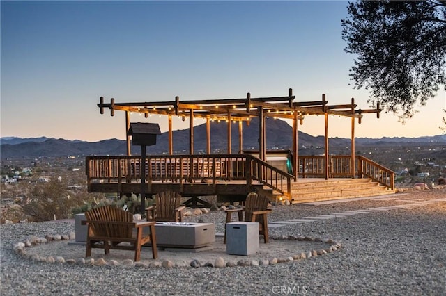 exterior space with a deck with mountain view and a fire pit