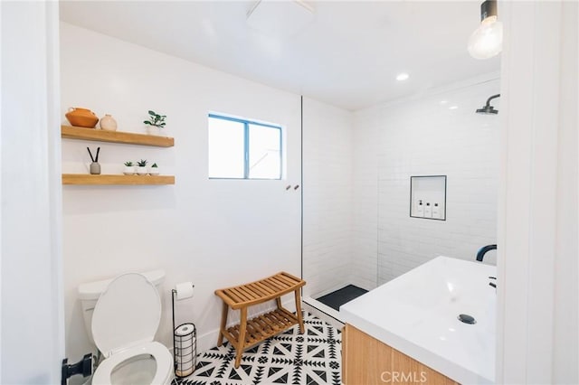 full bath with toilet, a tile shower, and vanity