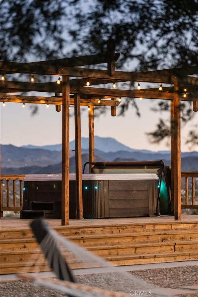 exterior space with a jacuzzi and a mountain view