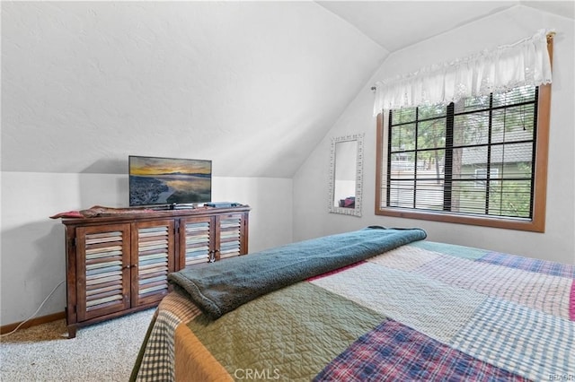 bedroom with vaulted ceiling, carpet floors, and baseboards