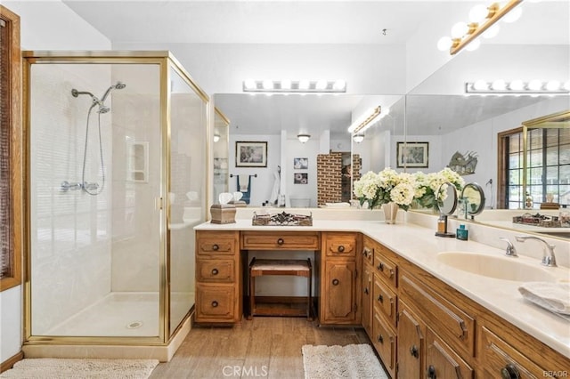 full bathroom with a shower stall, wood finished floors, and vanity