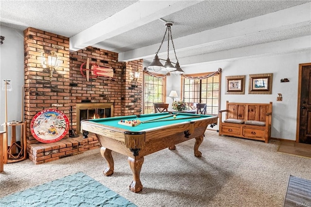 playroom featuring carpet floors, a brick fireplace, beam ceiling, and a textured ceiling