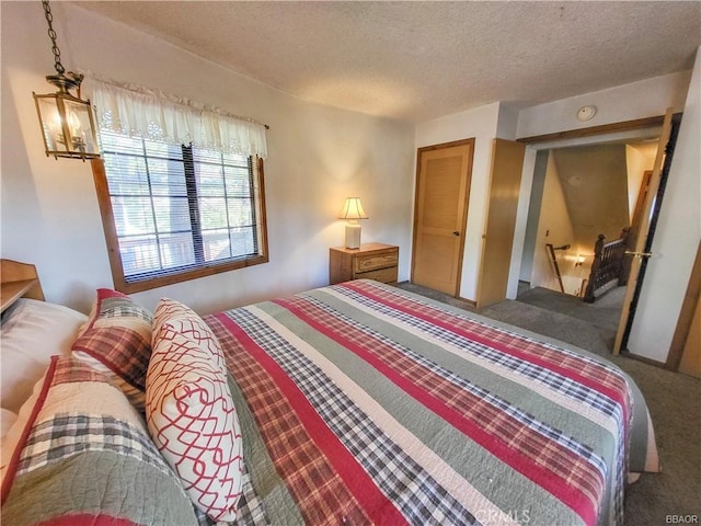 bedroom with a textured ceiling, carpet floors, and a chandelier