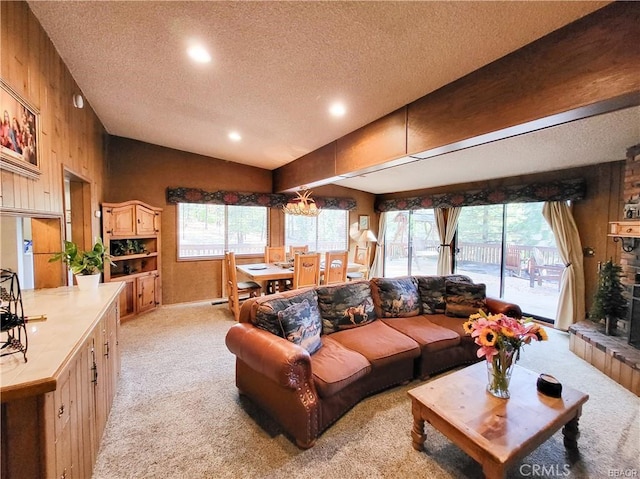 living area featuring a healthy amount of sunlight, light colored carpet, vaulted ceiling, and wood walls