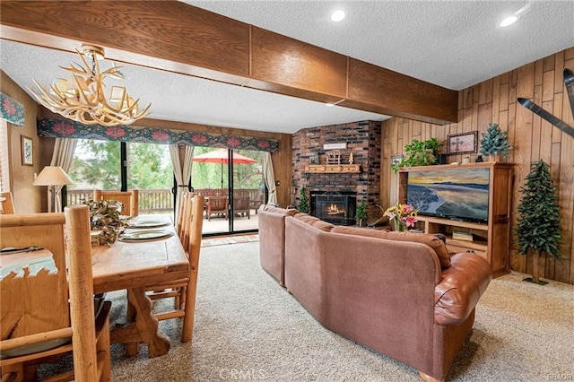 carpeted living room featuring a fireplace, wooden walls, and a textured ceiling