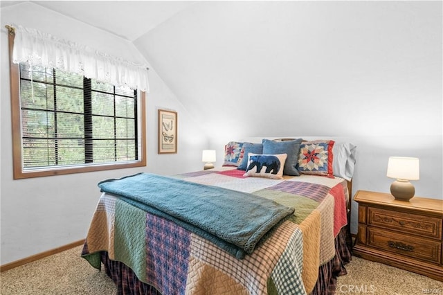 bedroom with carpet, baseboards, and vaulted ceiling