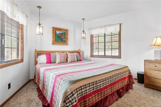 carpeted bedroom featuring multiple windows, baseboards, and a textured ceiling