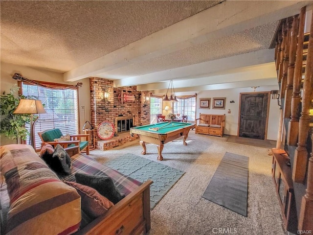 playroom with a textured ceiling, carpet, a wealth of natural light, and a brick fireplace