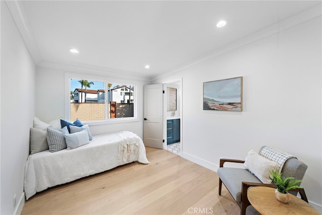 bedroom with recessed lighting, baseboards, light wood finished floors, ensuite bath, and crown molding