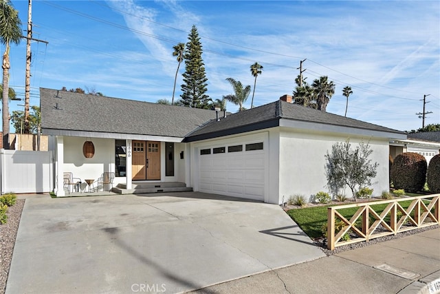 ranch-style house featuring an attached garage, a shingled roof, fence, driveway, and stucco siding