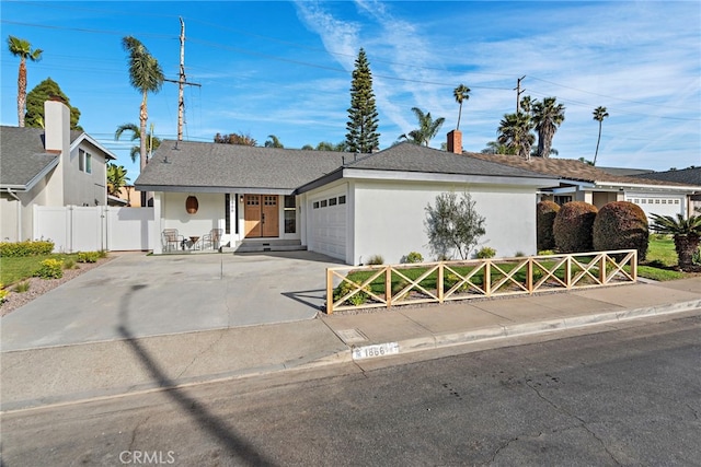 single story home featuring an attached garage, driveway, fence, and stucco siding