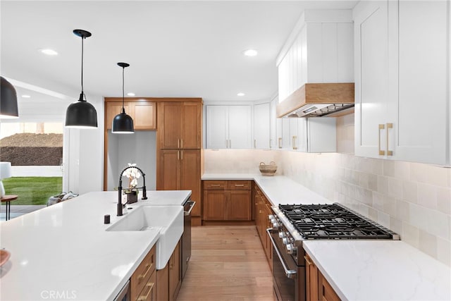 kitchen featuring light wood-type flooring, brown cabinets, decorative backsplash, stainless steel range, and custom range hood