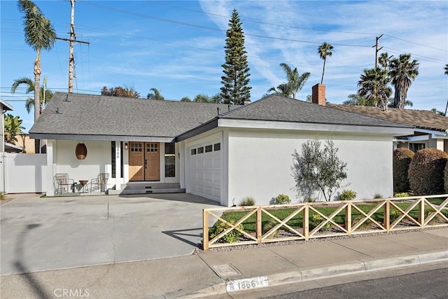 ranch-style home with a garage, driveway, a shingled roof, fence, and stucco siding