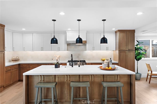 kitchen featuring a breakfast bar, light countertops, and light wood finished floors