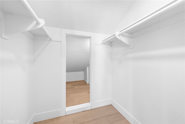 walk in closet with lofted ceiling and light wood finished floors