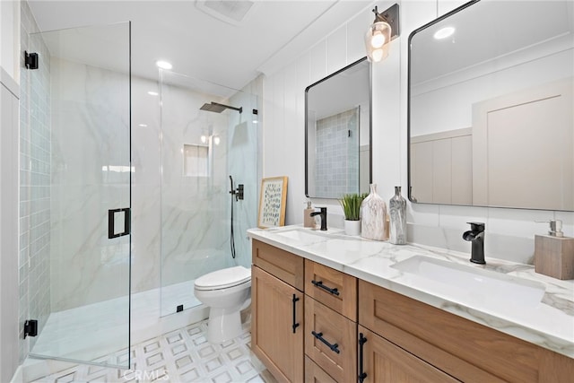 full bath featuring a marble finish shower, a sink, and toilet