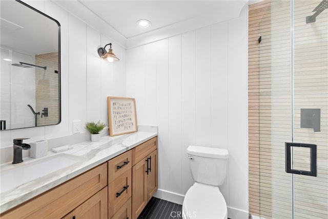 full bath featuring toilet, a stall shower, and vanity