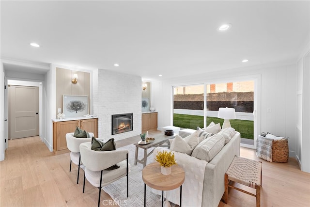 living area with light wood-style floors, a fireplace, and recessed lighting