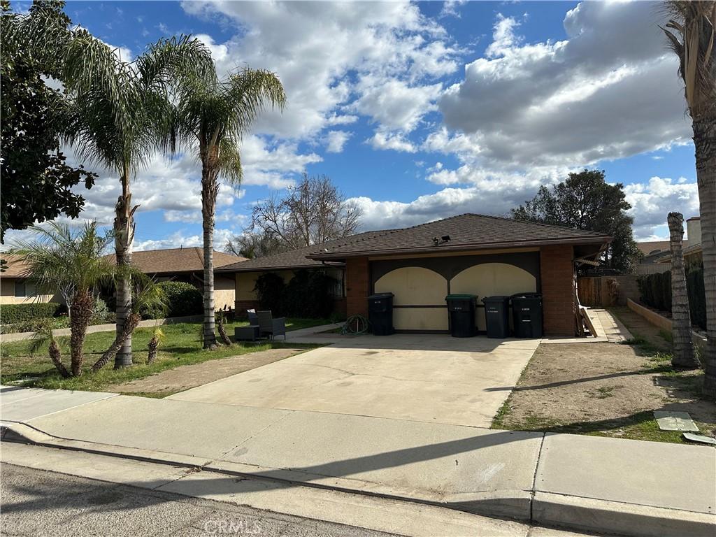 ranch-style home with a garage, fence, and concrete driveway