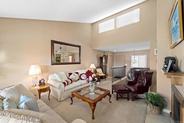 living room with a textured ceiling, a high ceiling, a fireplace with flush hearth, and visible vents