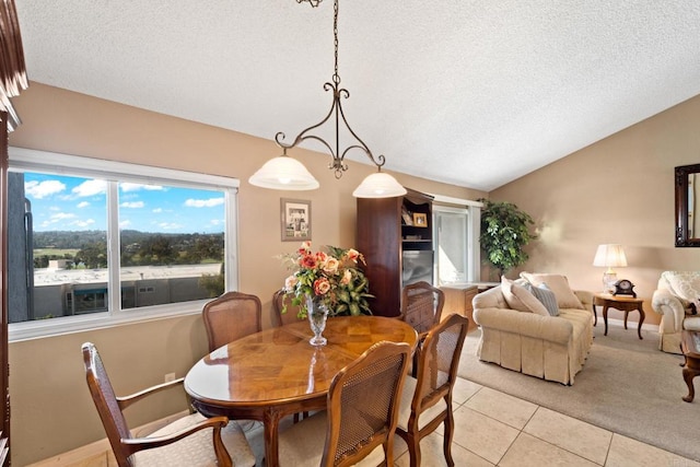 dining space featuring lofted ceiling, light tile patterned floors, a textured ceiling, and baseboards