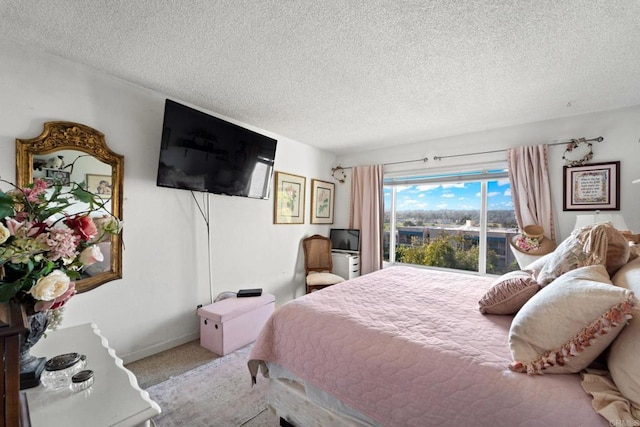 bedroom featuring carpet flooring, a textured ceiling, and baseboards