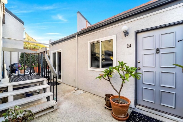 doorway to property with a patio and stucco siding