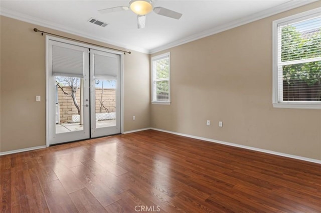 spare room featuring a ceiling fan, wood finished floors, visible vents, and ornamental molding