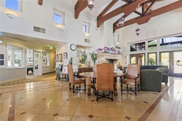 tiled dining room with beam ceiling, a fireplace, visible vents, and a wealth of natural light