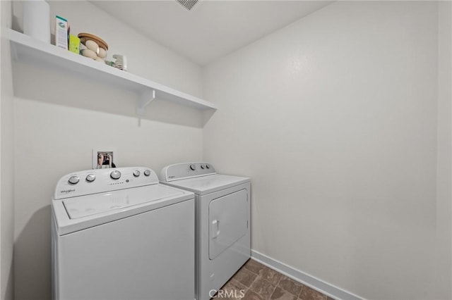 laundry room with laundry area, baseboards, and separate washer and dryer