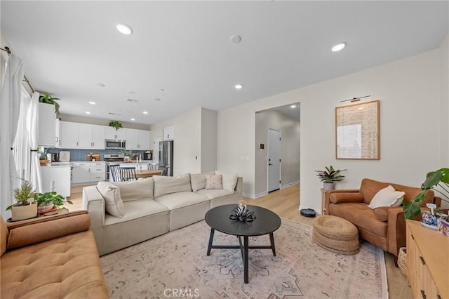 living area with light wood-type flooring and recessed lighting