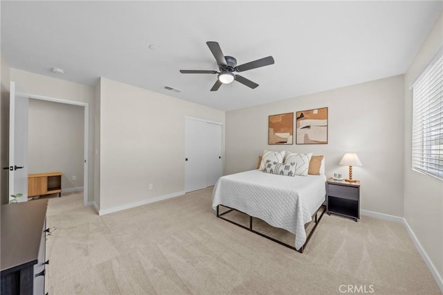 bedroom featuring light carpet, baseboards, visible vents, and a ceiling fan