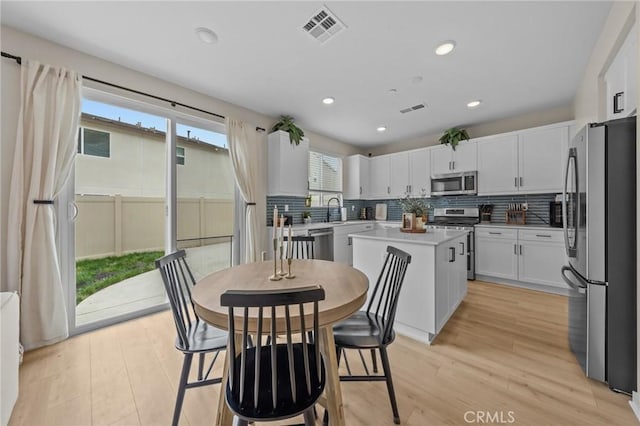 kitchen featuring white cabinetry, visible vents, appliances with stainless steel finishes, and a center island