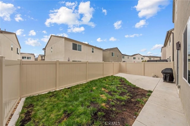 view of yard with a patio, a fenced backyard, and a residential view