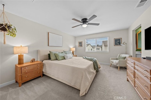 bedroom with a ceiling fan, visible vents, light carpet, and baseboards