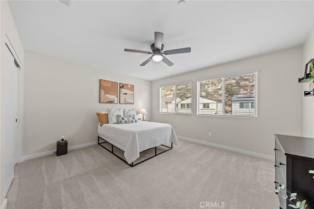 bedroom with baseboards, a closet, and light colored carpet