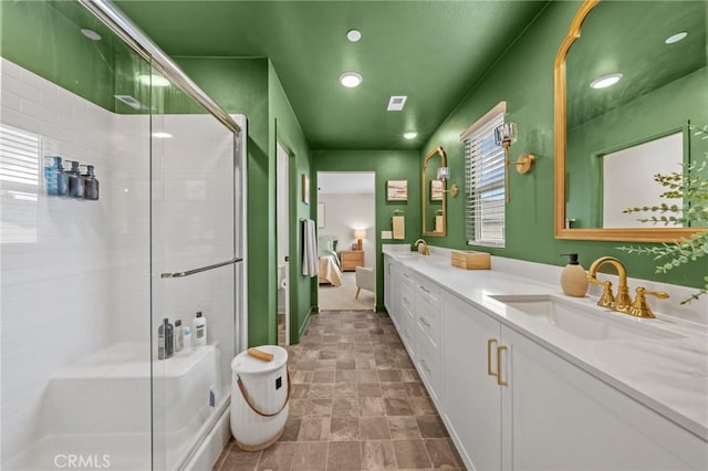 ensuite bathroom featuring a stall shower, a sink, visible vents, and connected bathroom