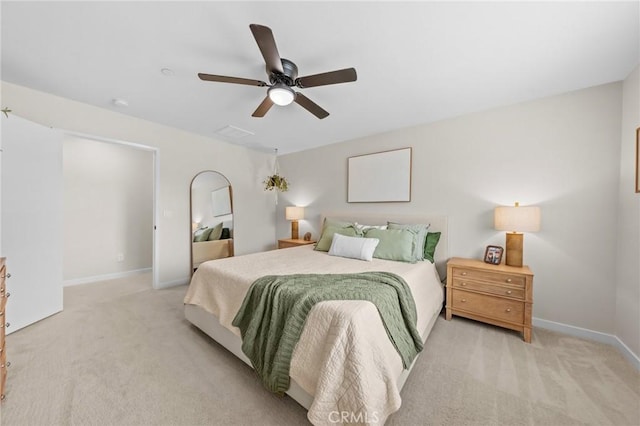 bedroom with a ceiling fan, light colored carpet, and baseboards