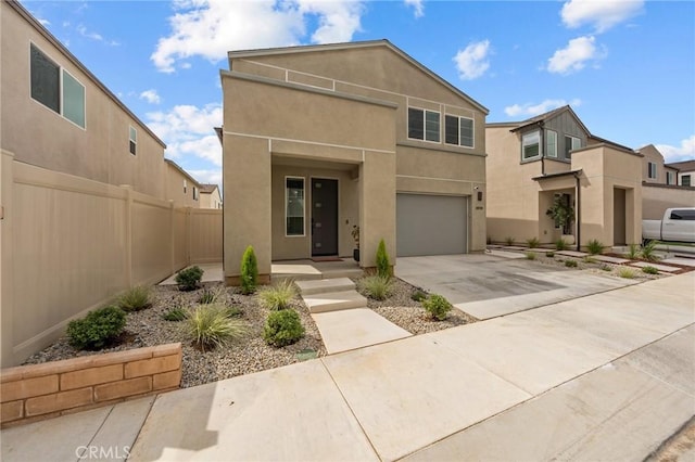 view of front of home with driveway, a garage, fence, and stucco siding