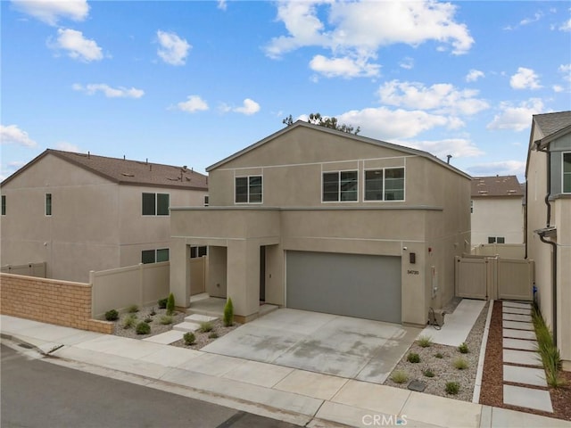 view of front of property featuring a garage, fence, driveway, a gate, and stucco siding