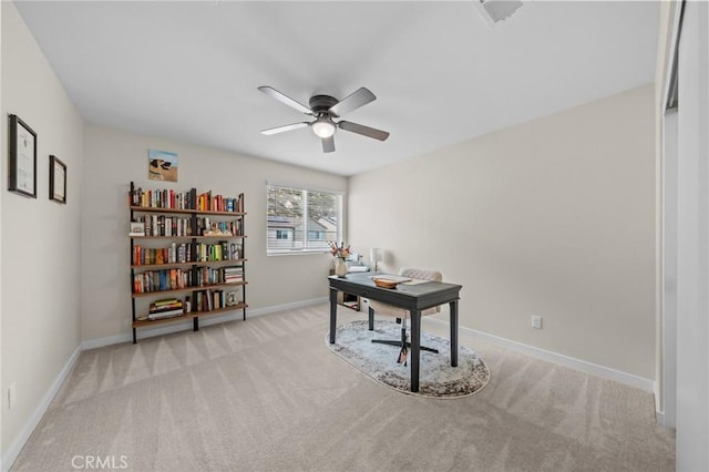 carpeted office with visible vents, baseboards, and a ceiling fan