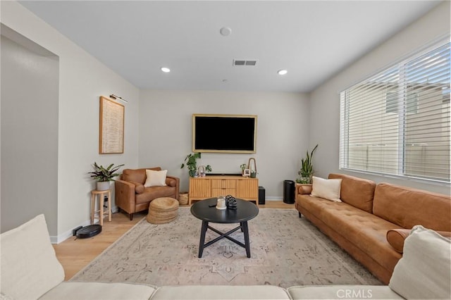 living room with recessed lighting, baseboards, visible vents, and light wood finished floors