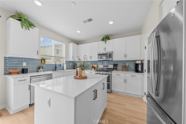 kitchen featuring appliances with stainless steel finishes, light countertops, visible vents, and light wood-style floors