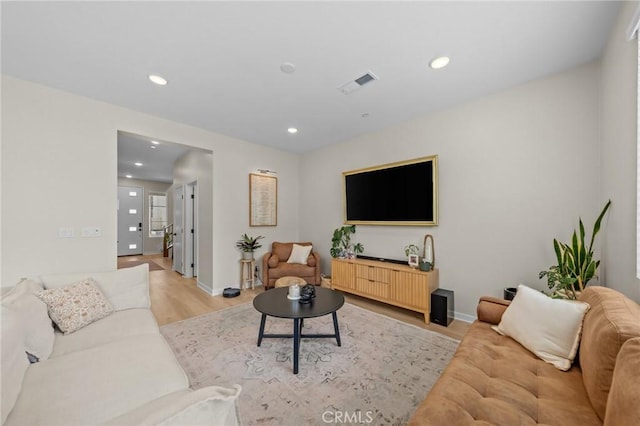 living area featuring baseboards, recessed lighting, visible vents, and light wood-style floors