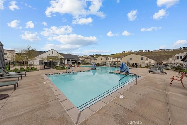 pool with a residential view, a patio area, and fence