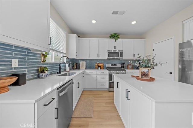 34720 Mustang Ln, Fallbrook, CA 92028 - kitchen featuring stainless steel appliances, light wood-type flooring, light countertops, white cabinetry, and tasteful backsplash