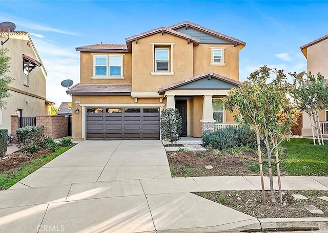 view of front of property with stucco siding, an attached garage, fence, driveway, and a tiled roof