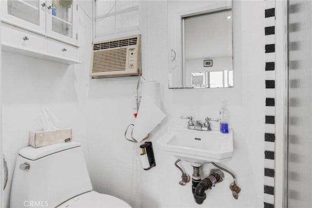 bathroom featuring a wall mounted air conditioner and toilet