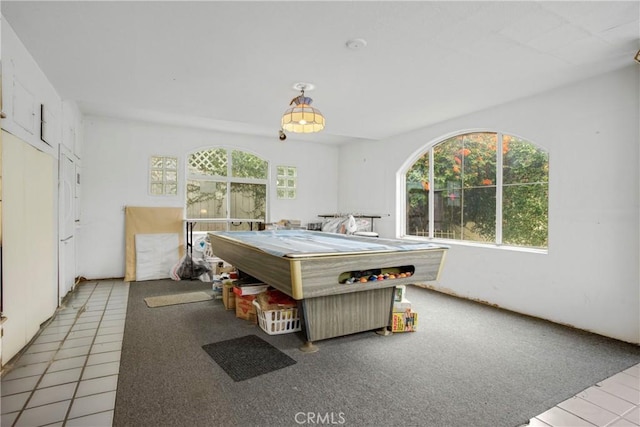 game room with tile patterned floors, carpet flooring, and a healthy amount of sunlight