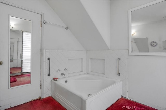 full bathroom featuring a tub to relax in and vaulted ceiling